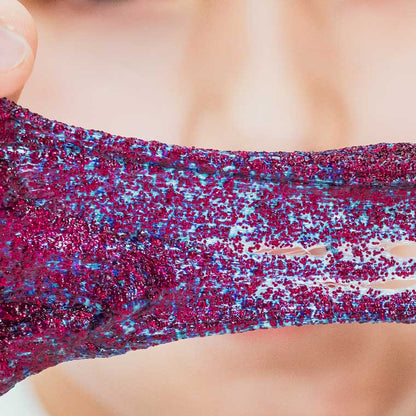 Close up detail of red glitter putty that looks blue when stretched.